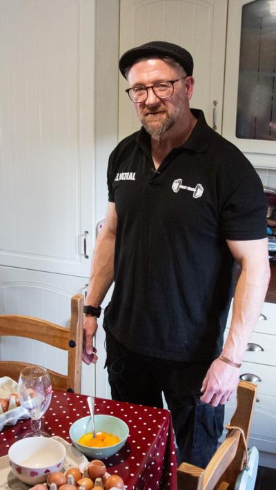 Clint Trayhern in a black polo shirt and flat cap stood over a bowl of eggs