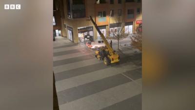 Phone footage from window shows yellow telehandler in middle of street pulling cash machine from Sainsburys