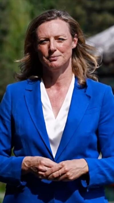 Laura Bicker stands in blue suit and looks into camera