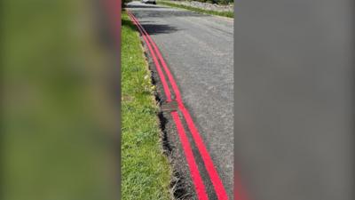 Double red lines painted on a road in the Peak District.