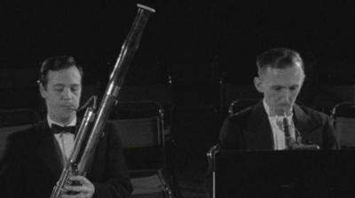 Two men play bassoons