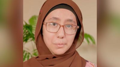 A women wears a brown hijab and brown glasses