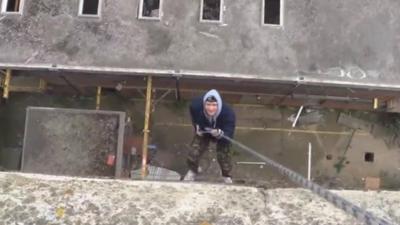 Man scaling derelict building