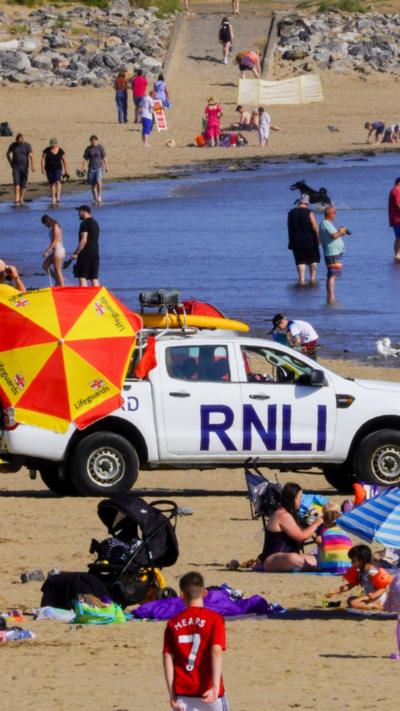 Traeth prysur gyda cerbyd RNLI