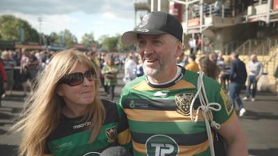 Northampton Saints fans - a man and a woman - outside their stadium.