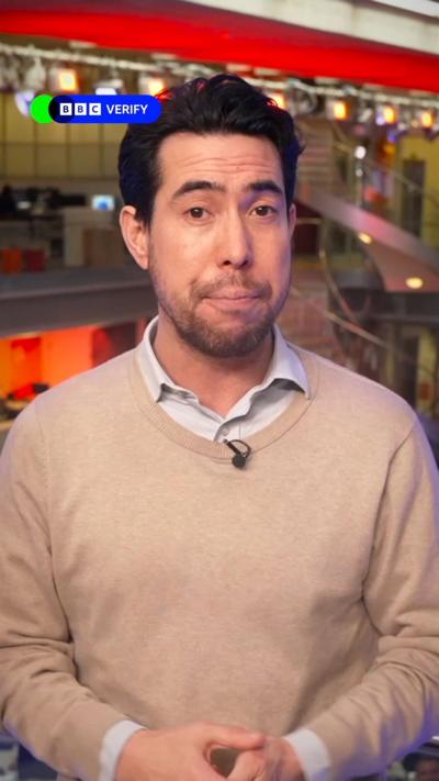 Presenter wearing blue shirt and beige knitwear