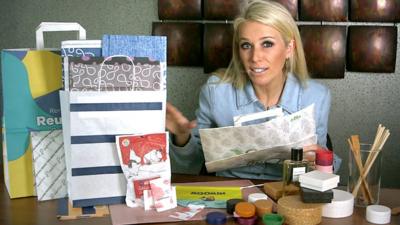 Lara Lewington sits next to a selection of containers derived from wood