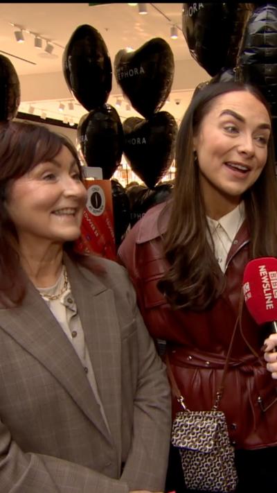 Two women smile at a camera 