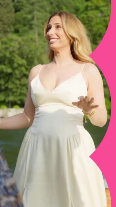 Stacey Solomon wears a white dress while standing on a boat, with a forest in the background