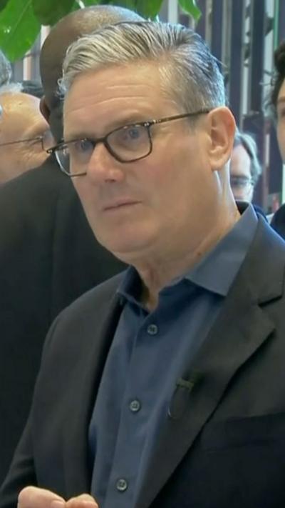 UK Prime Minister Keir Starmer wearing blue shirt and black blazer