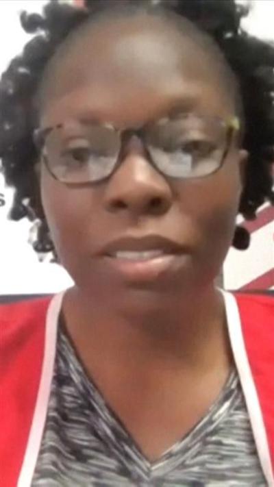Screengrab of Esther speaking on the news channel - she wears glasses and a red Red Cross vest