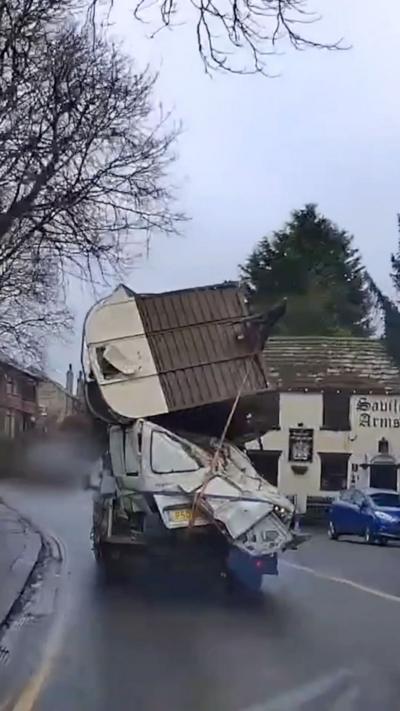 A vehicle with rubbish and material piled on top.