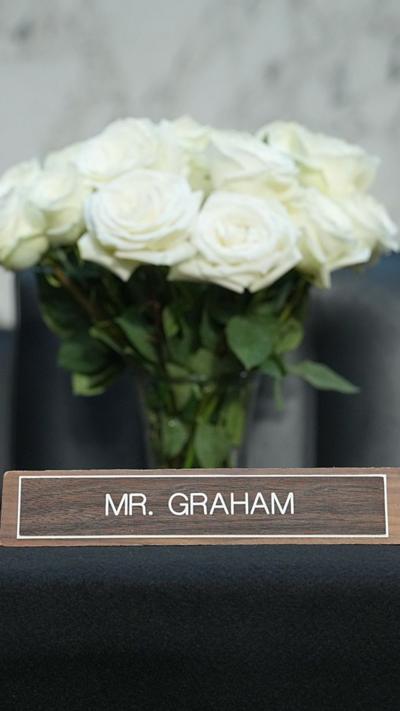 White roses are seen with the name plate of Mr. Graham in the fore ground.