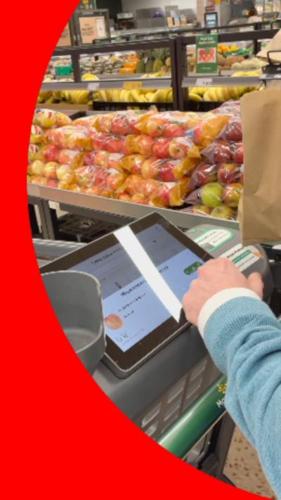 A shopping trolley with a small computer screen attached to the handle bar.