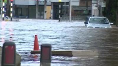 Partially submerged car in a flooded high street