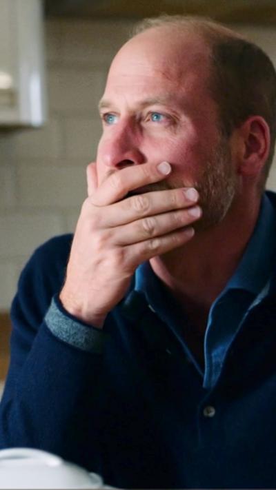 Prince William, with his hand over his mouth, with redder than usual cheeks and eyes after crying