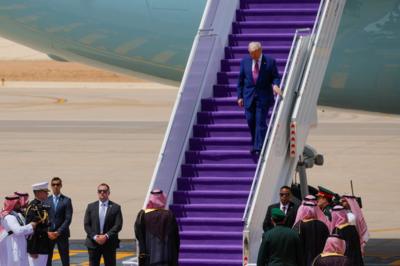 Trump walking down the step of a plane