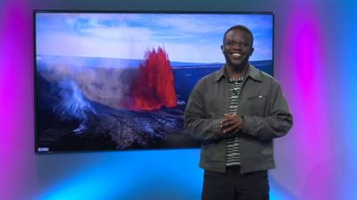 De-Graft in the studio with a volcano in the screen