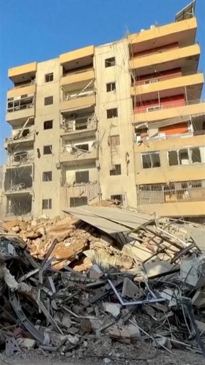 Damaged apartment building behind piles of rubble and debris