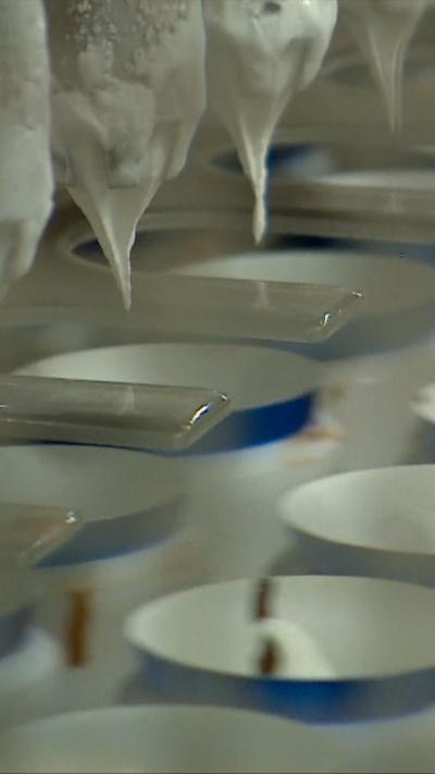 Ice cream being poured into tubs in a factory.