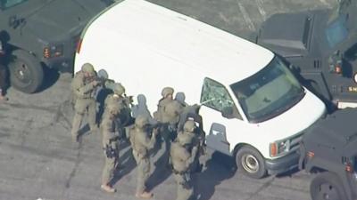 Armed police smash window of California shooting suspect's van