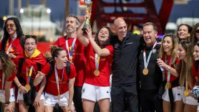 Ivana Andrés hold the World Cup trophy alongside her team mates at Madrid Airport