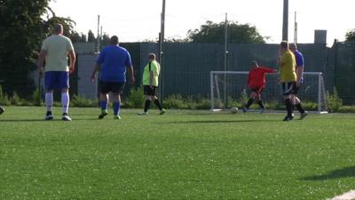 A footballer kicks a ball