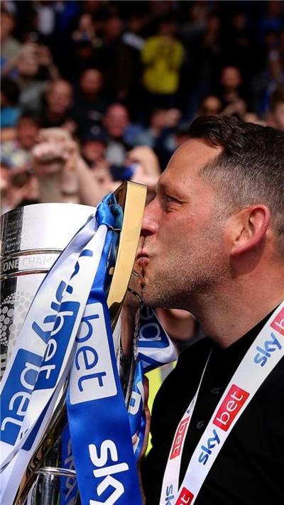 Leam Richardson kisses a trophy.