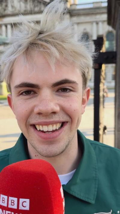 A man with blonde hair is smiling into the camera.
