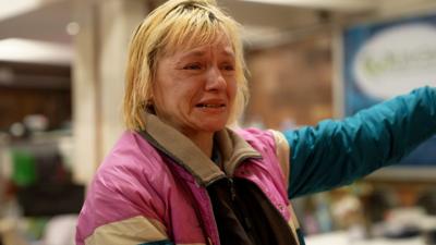 Woman in pink jacket crying