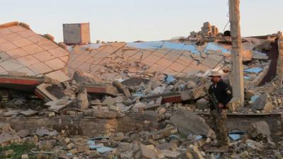 Member of Iraqi security forces stands in rubble outside Ramadi