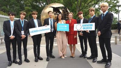 BTS-UNICEF-stand-together-in-front-of-a-sculpture.