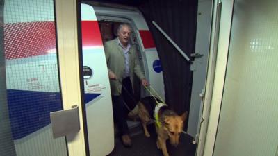 Ian and his guide dog disembark a plane