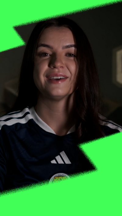 Woman with long dark hair in Scotland football top