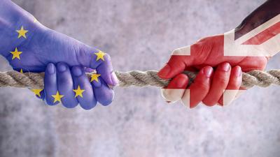 A tug of war between hands decorated in the EU and Union flags