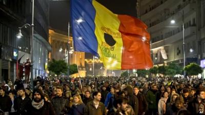 Large flag and crowds of protesters in Calea Victoriei