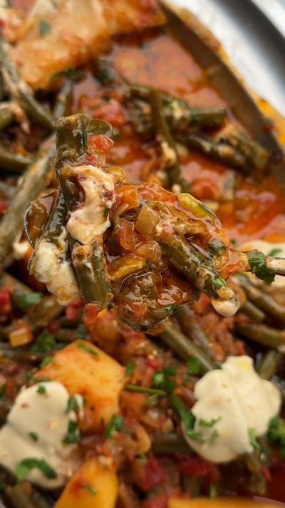A close-up of the Cypriot dish, fasolakia, which contains tomatoes, green beans and potatoes.