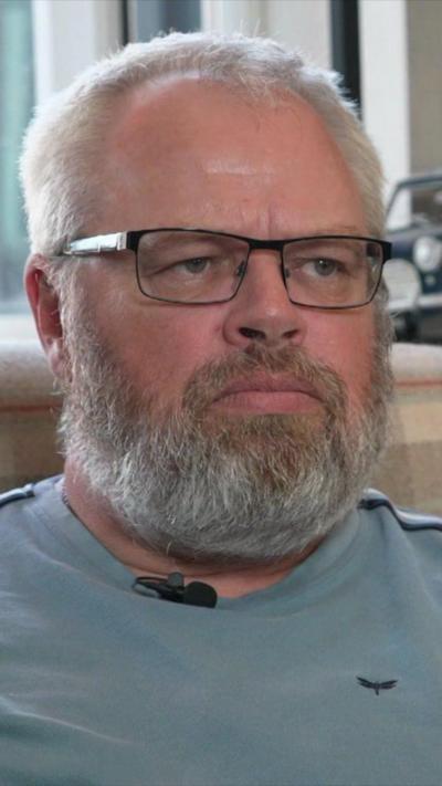 Close up middle-aged man with grey beard, glasses and receding white hair