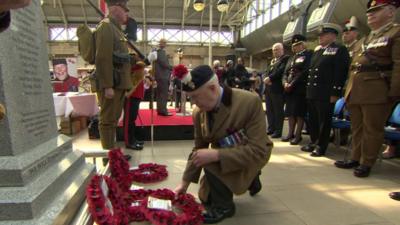 Man laying a wreath at a war memorial