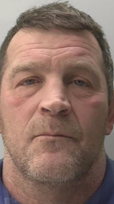 Police mugshot of Paul Quinn he has short brown hair and a short beard
