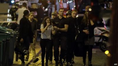 Rescuers evacuate people following an attack in the 10th arrondissement of the French capital Paris