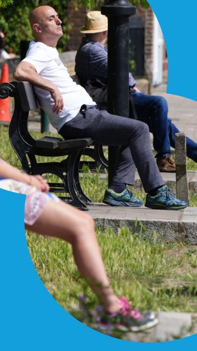 Side view of people in London sitting on park benches in the sun