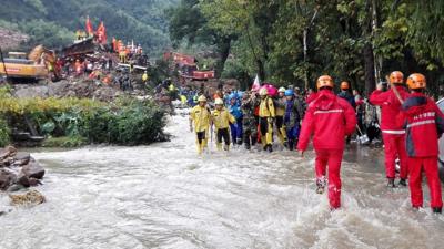 Rescuers carry out an injured from the site of a landslide in Suichang county, Zhejiang province, China, 29 September 2016