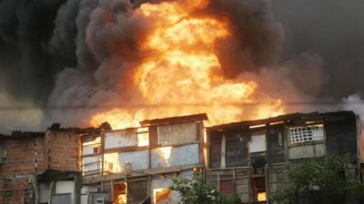 Flames rising from homes on a hill