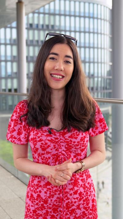 Sabrina Lee, who has long dark hair and is wearing a pink dress