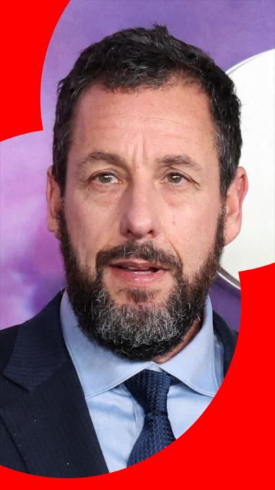 Adam Sandler during a red carpet event, wearing a blue suit