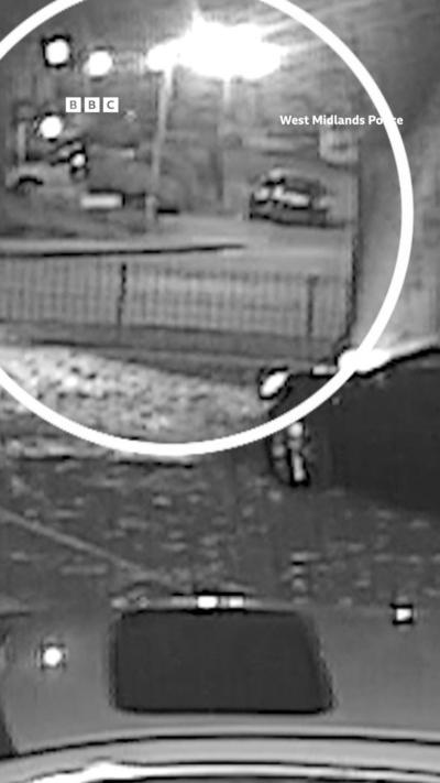Grainy CCTV footage showing three cars in a car park and a white circle denoting where a firework attack took place at a house