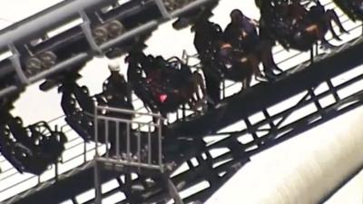 Rescue workers are seen next to people stuck in the Arkham Asylum roller coaster ride at the Warner Bros. Movie World theme park in Gold Coast, Australia