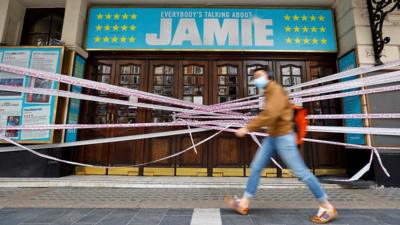 A person walks past a closed theatre in London in a file photo dated 6 July 2020