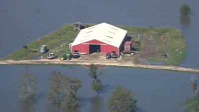 Texas farm building surrounded by floodwater